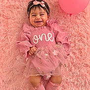 Ammarah is registered to the contest to win money with this photo: baby, child, pink, balloon, smile, dress, headband, sock, fluffy_rug, happy, portrait, one_year_old, cute, infant, lying_down, celebration, soft_texture, toddler, person, fun