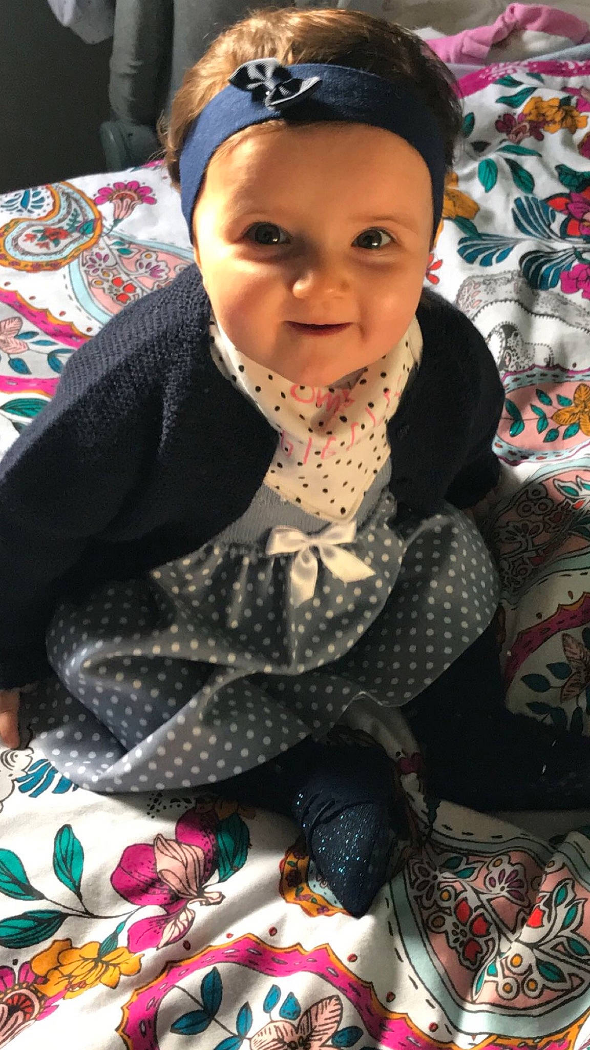 Luanna a rejoint le concours — aidez-le/la à gagner de superbes lots ! cap, child, craft, event, eye, fashion_accessory, fun, happy, headgear, headwear, outerwear, pattern, person, room, shawl, sitting, smile, textile, toddler, tradition