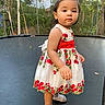 toddler, child, dress, floral_dress, trampoline, backyard, greenery, trees, leaves, socks, standing, portrait, outdoor, cute, young_child, person, nature, daylight, curious, photography