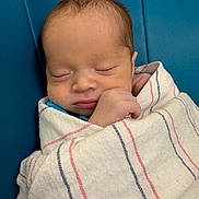 Josue is registered to the contest to win money with this photo: newborn, baby, sleeping, blanket, wrapped, blue_background, peaceful, infant, closeup, portrait, soft, resting, cute, tiny, hand, face, skin, indoors, comfort, serene