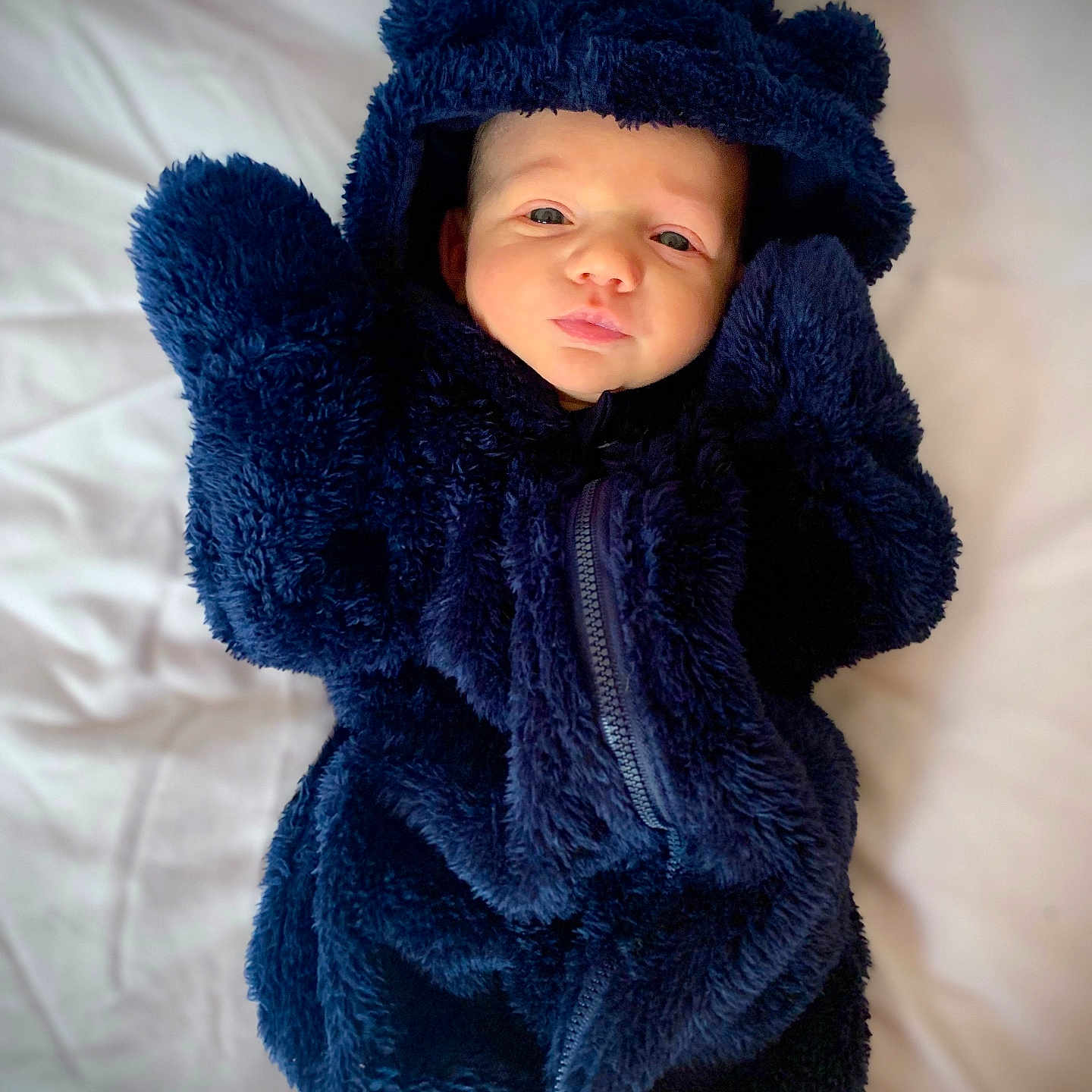 Liam is registered to the contest to win money with this photo: baby, blanket, bonnet, cap, clothing, coat, face, happy, hat, head, hood, hoodie, jacket, knitwear, newborn, person, photography, portrait, sweater, sweatshirt