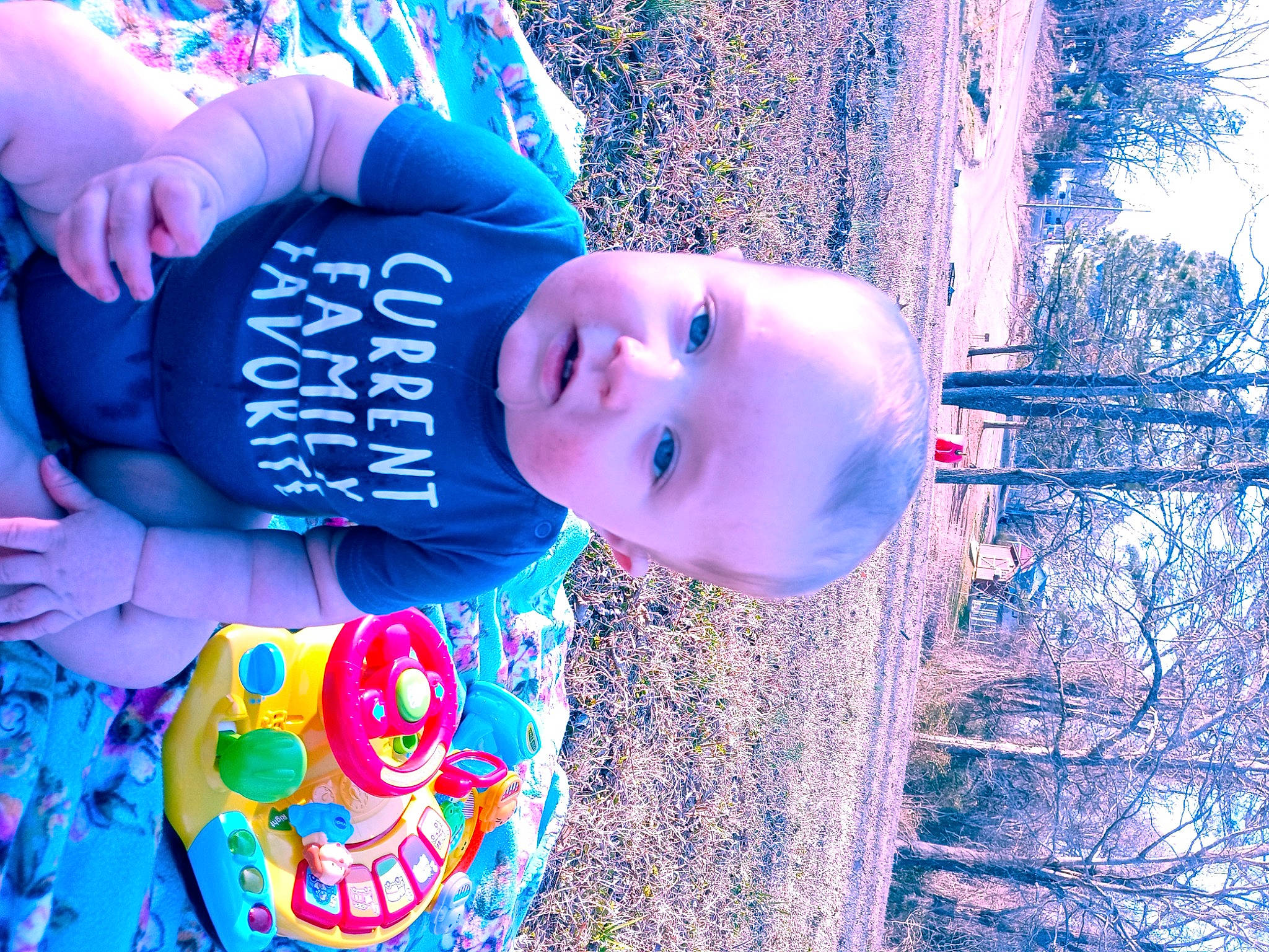 Paxton is registered to the contest to win money with this photo: azure, baby, blue, eye, face, flash_photography, happy, hat, head, headgear, human_body, mouth, organ, person, plant, purple, sky, smile, toddler, tree