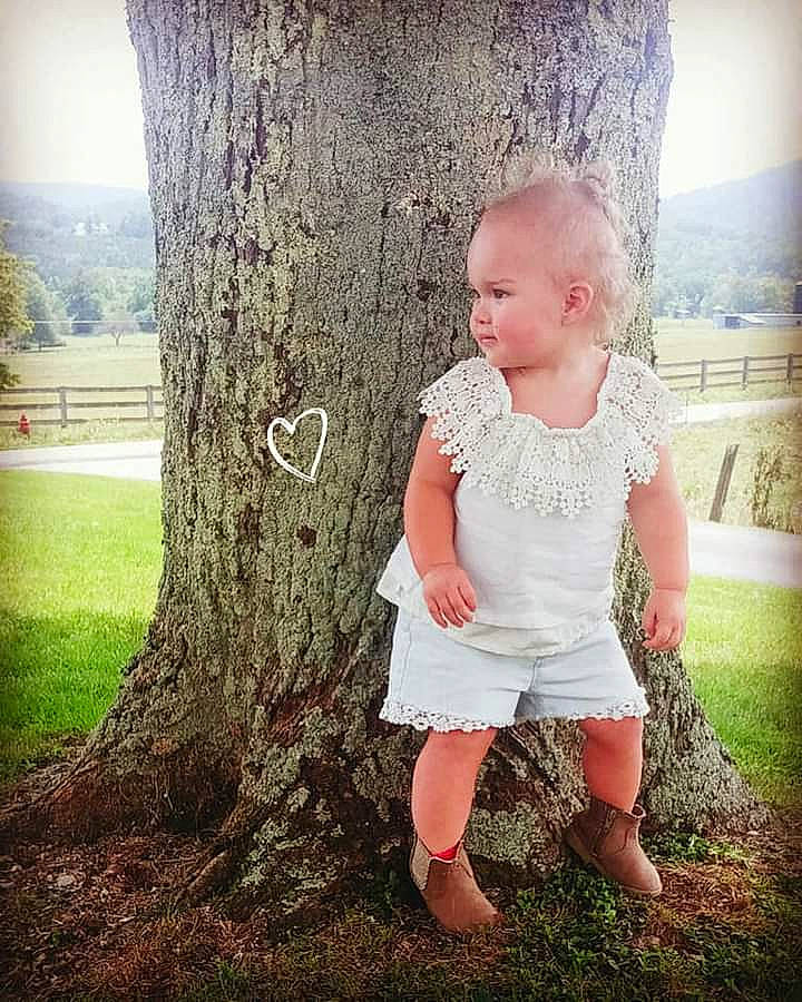 Audreena is registered to the contest to win money with this photo: baby_toddler_clothing, eye, facial_expression, flash_photography, gesture, grass, green, hairstyle, happy, head, human_body, leaf, leg, people_in_nature, person, plant, skin, standing, sunlight, tree