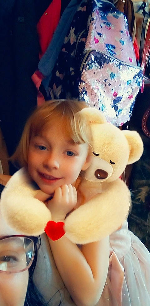 Patricia is registered to the contest to win money with this photo: bangs, beauty, blond, child, event, fun, gesture, happy, human_leg, joy, lip, mammal, nose, person, pink, skin, smile, teddy_bear, textile, thumb