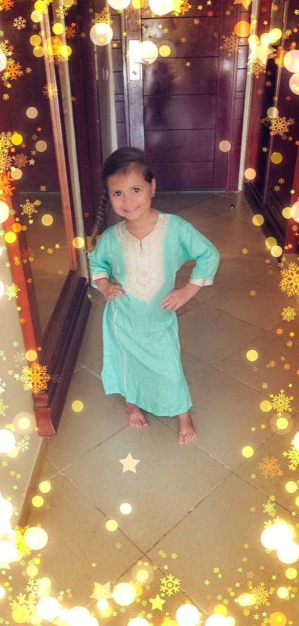 Jamila a rejoint le concours — aidez-le/la à gagner de superbes lots ! child, christmas_decoration, christmas_ornament, door, dress, event, flooring, formal_wear, fun, happy, holiday, joy, leisure, ornament, person, room, sitting, standing, toddler, tradition