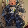 baby, infant, onesie, plaid, blue, baby_seat, cushion, blanket, cute, cozy, indoor, child, face, clothing, soft, newborn, person, expression, warm, comfort