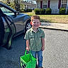 Jaxon joined the competition — help win amazing prizes! child, boy, smiling, green_shirt, jeans, boots, green_basket, minecraft_theme, car, car_door, street, sidewalk, grass, bushes, house, window, tree, sunny, daytime, outdoor