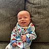 Brayden is registered to the contest to win money with this photo: baby, smile, onesie, couch, happy, infant, child, face, seacreatures, whale, crab, fish, blue, red, patterned_clothing, sitting, portrait, indoor, texture, cute