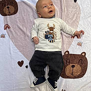 Milo participe au concours pour gagner de l'argent avec cette photo : animal_print, baby, bear, blanket, blue_eyes, child, clothing, cute, happy, heart, indoors, infant, lying_down, pants, portrait, shirt, shoes, smiling, soft_texture, toddler