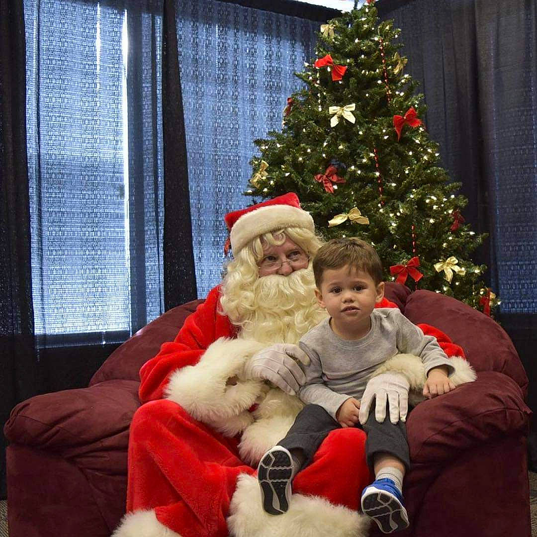 D'Artagnan is registered to the contest to win money with this photo: christmas, christmas_decoration, christmas_tree, event, fictional_character, holiday, lap, person, santa_claus, tree