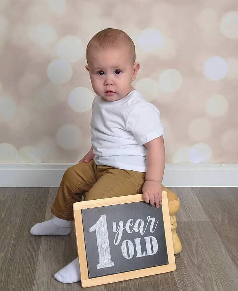 Kaydan joined the competition — help win amazing prizes! baby, baby_toddler_clothing, chair, child, comfort, flooring, font, happy, hardwood, knee, person, rectangle, sitting, sleeve, t_shirt, table, toddler, varnish, wood, wood_flooring