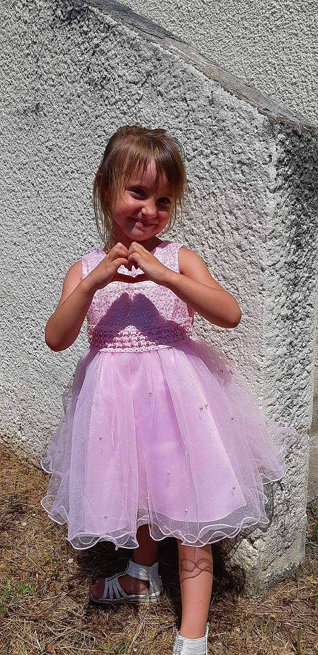 Kelia a rejoint le concours — aidez-le/la à gagner de superbes lots ! baby_toddler_clothing, beauty, child, day_dress, dress, embellishment, fun, grass, happy, joy, magenta, one_piece_garment, pattern, person, pink, purple, ruffle, sitting, sleeve, smile