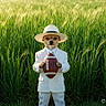 Molly is registered to the contest to win money with this photo: animal, canine, costume, dog, fashion, field, football, funny, grass, greenery, hat, nature, outdoor, portrait, single_animal, sports, standing, summer, sunlight, white_suit