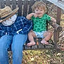 toddler, child, scarecrow, swing, wooden_swing, outdoor, grass, leaves, fall, plaid_shirt, jeans, straw_hat, fake_spider_web, barefoot, green_shirt, diaper, smiling, person, bench, holiday_decoration
