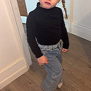 Fiby participe au concours pour gagner de l'argent avec cette photo : child, toddler, girl, braid, pigtail, black_turtleneck, jeans, denim, socks, standing, pose, red_eyes, indoor, doorframe, hardwood_floor, wall, portrait, candid_photo, smirk, fashion