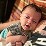 Violet is registered to the contest to win money with this photo: baby, infant, striped_shirt, sleepy, close_up, cuddling, comfort, adult, arm, blanket, striped_blanket, indoor, portrait, human, skin, hair, expression, resting, holding, casual