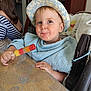 Marceau a rejoint le concours — aidez-le/la à gagner de superbes lots ! toddler, child, hat, popsicle, table, towel, bib, blue_eyes, indoor, high_chair, person, food, snack, happy, cute, home, adult, striped_clothing, face, portrait