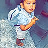 toddler, child, backpack, striped_shirt, white_overalls, sandals, elevator, metal_wall, floor, curious, standing, indoor, young_child, short_hair, looking_up, small_child, casual_clothing, footwear, person, portrait