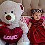Cataleya participe au concours pour gagner de l'argent avec cette photo : toddler, child, teddy_bear, plush_toy, red_dress, heart_shaped_sunglasses, bed, pillow, love, soft_toy, cute, indoor, portrait, smile, cuddly, decor, seated, cozy, toy, young_child