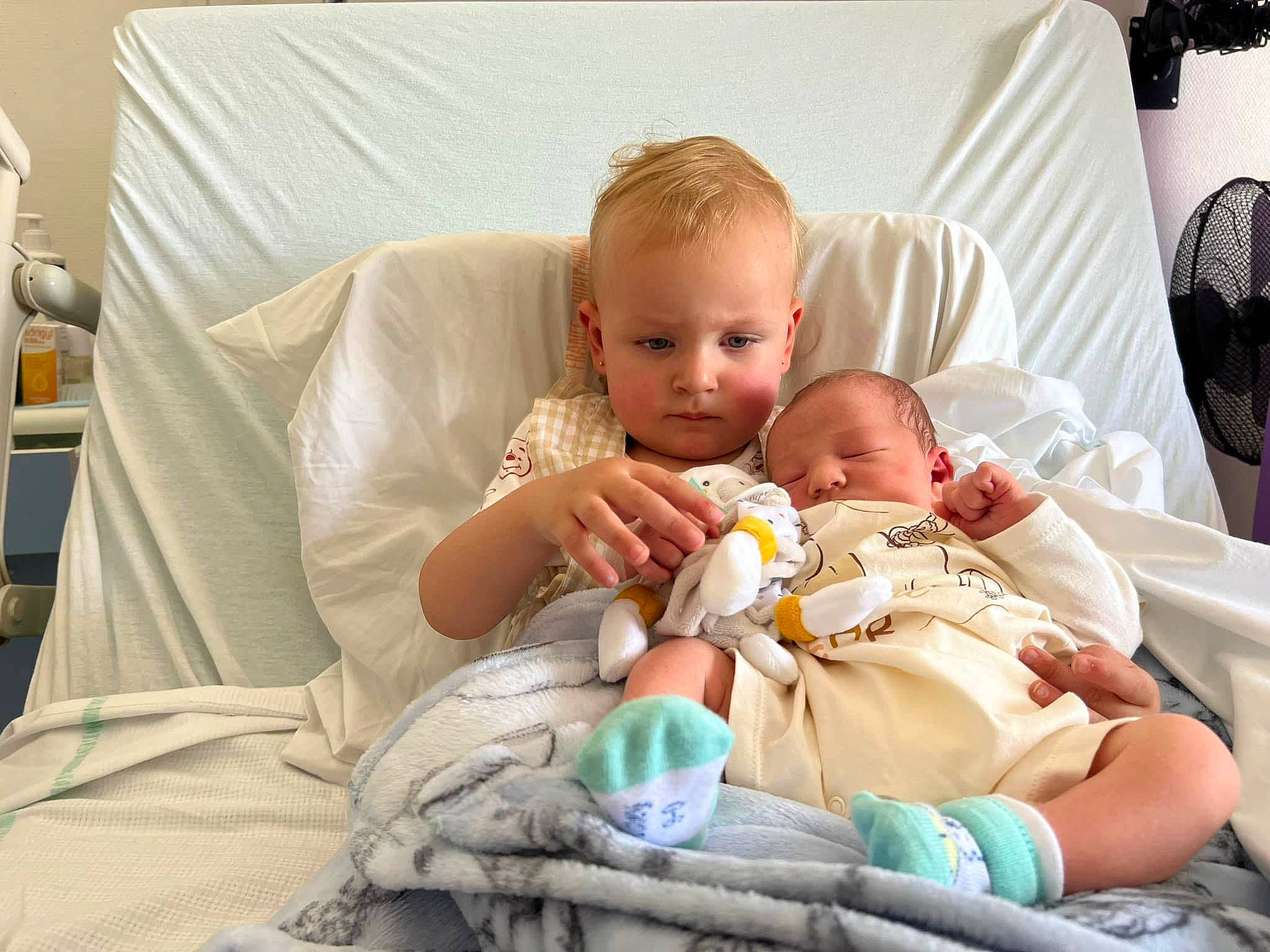 Chelsea participe au concours pour gagner de l'argent avec cette photo : abdomen, baby, baby_products, baby_toddler_clothing, child, comfort, couch, event, eye, hand, happy, knee, lamp, linens, mechanical_fan, person, room, sitting, skin, throw_pillow