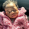 baby, sleeping, pink_jacket, curly_hair, fluffy, close_up, child, soft_light, cozy, peaceful, portrait, infant, warm_clothing, cute, face, relaxation, indoors, young_child, toddler, adorable