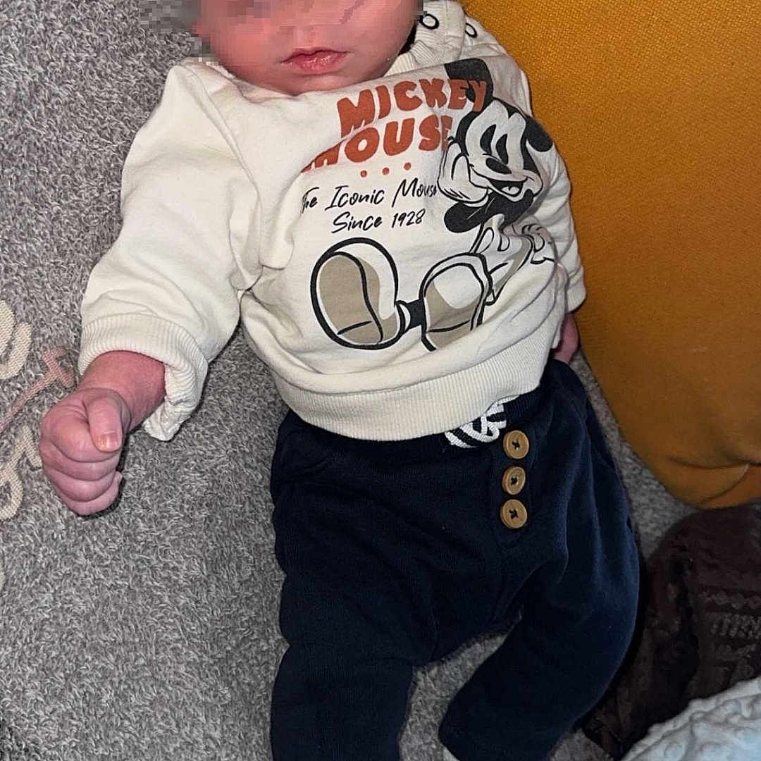 Djoulyano a rejoint le concours — aidez-le/la à gagner de superbes lots ! baby, blanket, carpet, casual, child, clothing, comfort, cute, indoor, infant, lying_down, mickey_mouse, newborn, pants, person, pillow, resting, socks, soft_texture, sweater