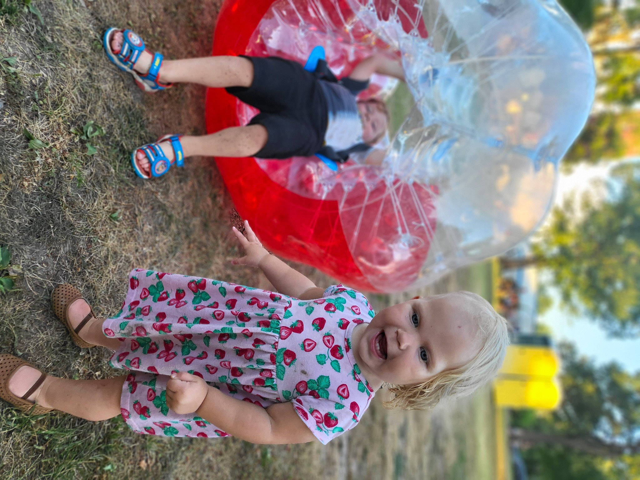 Avie is registered to the contest to win money with this photo: arm, blue, clothing, fun, hand, happy, leg, leisure, people_in_nature, person, pink, plant, public_space, red, shorts, smile, sneakers, summer, sunglasses, tree