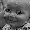 Maximus is registered to the contest to win money with this photo: baby, child, infant, portrait, close_up, face, smiling, happy, eyes, blond_hair, black_and_white, photography, indoor, clothing, hooded_shirt, head, looking_at_camera, soft_lighting, adorable, person