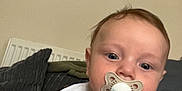 Hunter is registered to the contest to win money with this photo: baby, pacifier, infant, closeup, face, hand, blanket, couch, indoor, child, curious, blue_eyes, clothing, person, young, portrait, cute, toddler, relaxed, soft_lighting