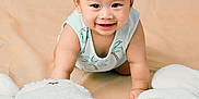 Rei is registered to the contest to win money with this photo: baby, smiling, crawling, pillow, plush, white, cute, child, indoors, soft, infant, happy, person, face, short_hair, sleeveless_shirt, background, toy, comfort, playful