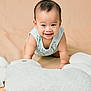 baby, smiling, crawling, pillow, plush, white, cute, child, indoors, soft, infant, happy, person, face, short_hair, sleeveless_shirt, background, toy, comfort, playful