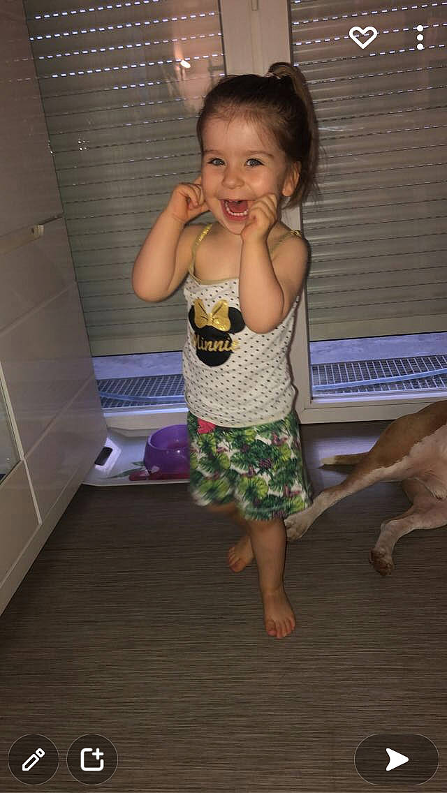 Lou a rejoint le concours — aidez-le/la à gagner de superbes lots ! baby_toddler_clothing, barefoot, child, eye, face, facial_expression, floor, flooring, fun, happy, hardwood, human_leg, leg, leisure, person, skin, smile, standing, thigh, toddler