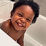 Kyren is registered to the contest to win money with this photo: child, toddler, smiling, bathtub, water, curly_hair, bath_time, happy, indoors, skin, face, teeth, playful, baby, fun, splash, bathroom, cute, joy, person