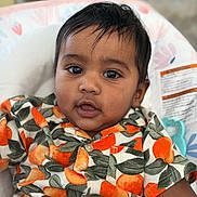 Suhaan is registered to the contest to win money with this photo: baby, child, face, portrait, clothing, orange_pattern, curly_hair, cute, infant, closeup, sitting, indoors, person, shirt, happy, young_child, head, skin, smiling, eyes