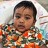 baby, child, face, portrait, clothing, orange_pattern, curly_hair, cute, infant, closeup, sitting, indoors, person, shirt, happy, young_child, head, skin, smiling, eyes
