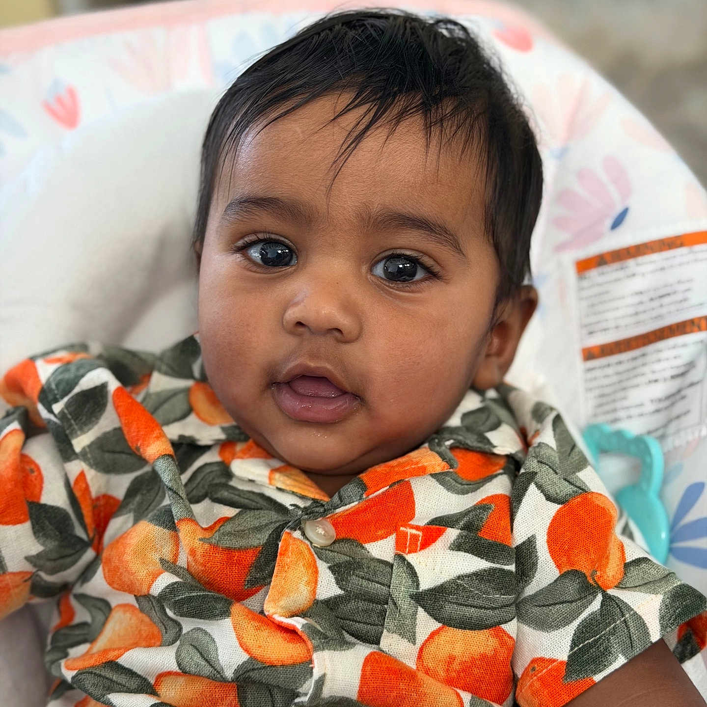 Suhaan is registered to the contest to win money with this photo: baby, child, face, portrait, clothing, orange_pattern, curly_hair, cute, infant, closeup, sitting, indoors, person, shirt, happy, young_child, head, skin, smiling, eyes