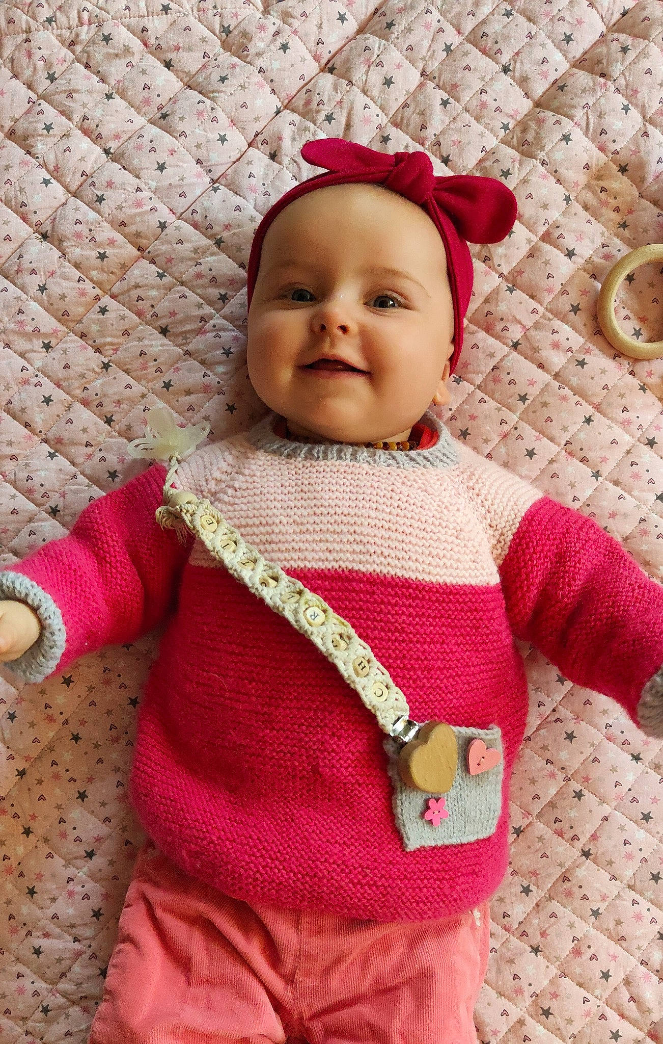 Charlotte a rejoint le concours — aidez-le/la à gagner de superbes lots ! baby, baby_toddler_clothing, cheek, child, dress, eye, face, flooring, happy, lip, magenta, outerwear, pattern, person, pink, red, skin, sleeve, smile, textile
