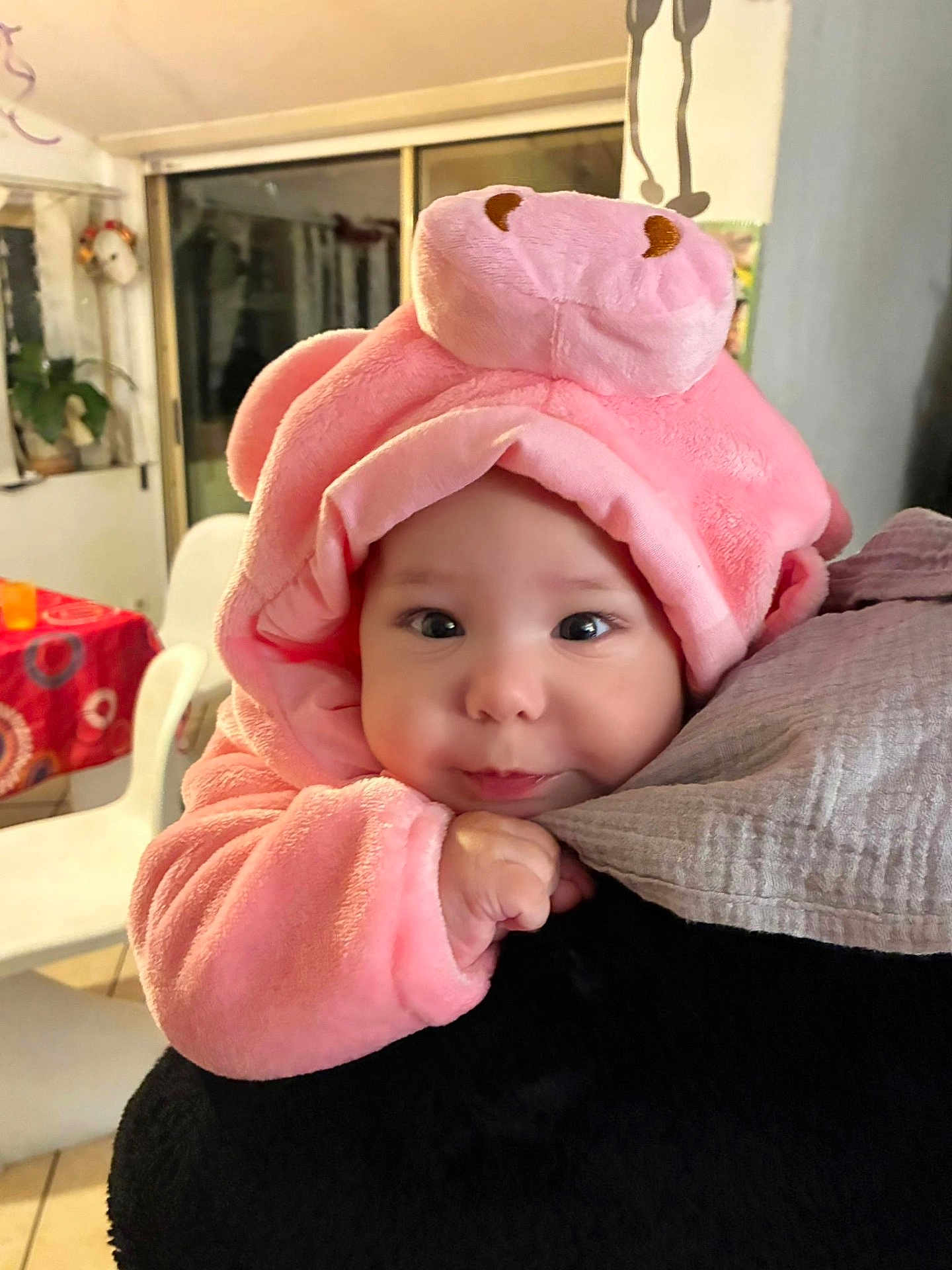 Soléna participe au concours pour gagner de l'argent avec cette photo : baby, infant, pink_hood, plush_hat, cute, big_eyes, chubby_cheeks, hand, coat, closeup, indoor, dining_room, chair, blanket, warm_clothing, portrait, soft_texture, adorable, gaze, parent_arm
