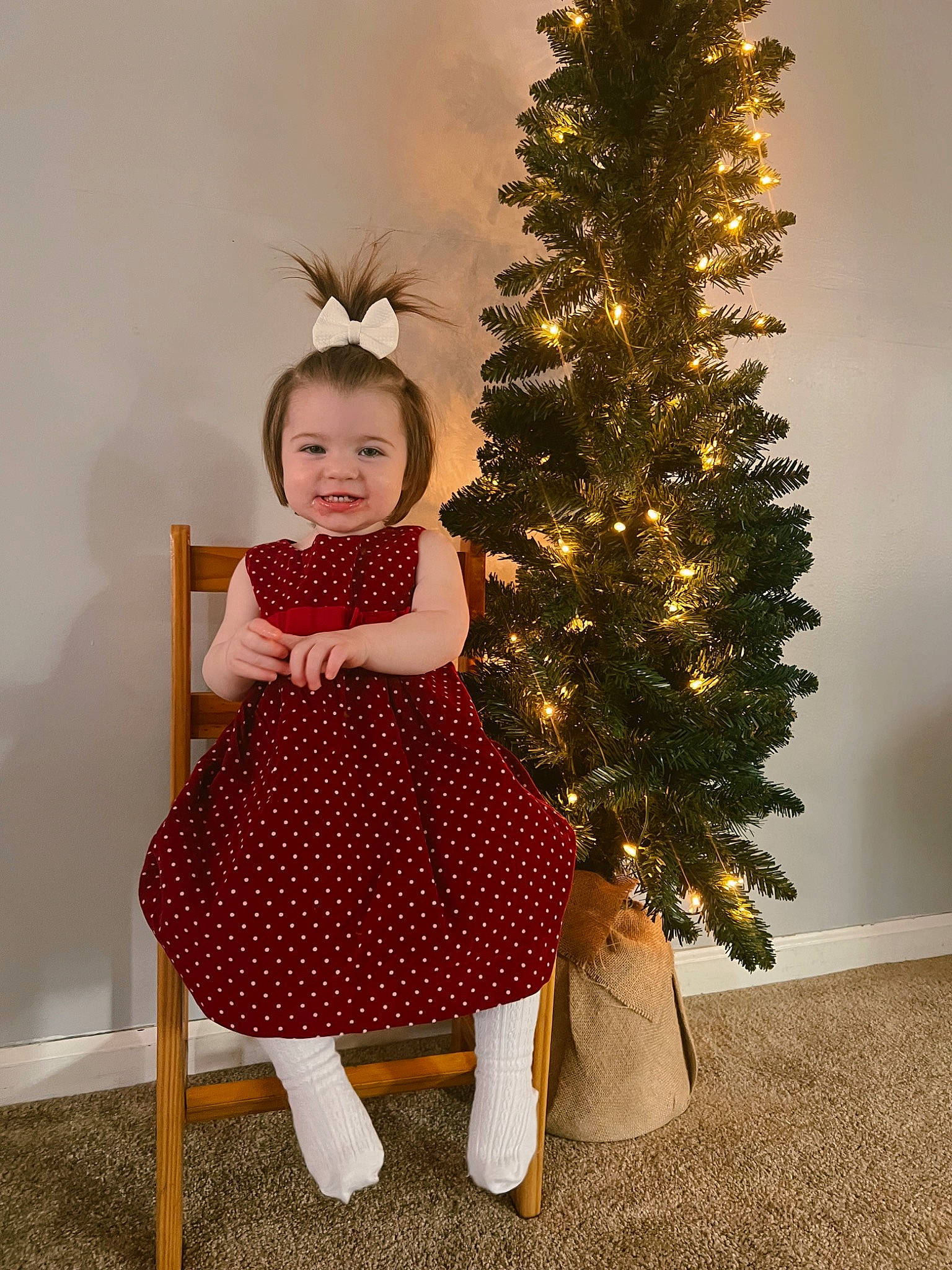 Haevyn is registered to the contest to win money with this photo: baby_toddler_clothing, christmas, christmas_decoration, christmas_ornament, christmas_tree, event, evergreen, face, happy, holiday, holiday_ornament, human_body, joy, ornament, person, plant, sleeve, smile, sock, toddler