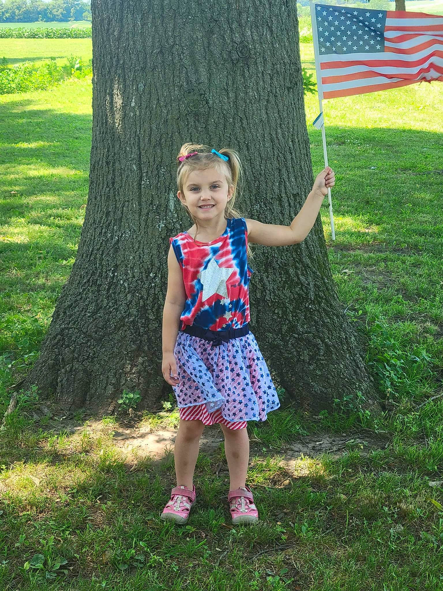 Everlynn is registered to the contest to win money with this photo: baby_toddler_clothing, botany, clothing, eye, flag, footwear, grass, grassland, green, happy, joy, lawn, leaf, leisure, people_in_nature, person, plant, smile, summer, terrestrial_plant