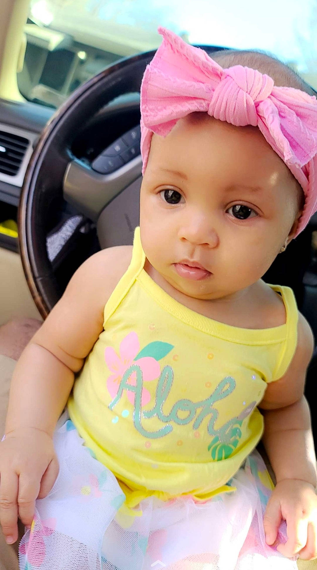 Draya is registered to the contest to win money with this photo: automotive_tire, baby, baby_toddler_clothing, cap, cheek, chin, cool, face, hairstyle, happy, headwear, lip, motor_vehicle, person, pink, plant, skin, sleeve, steering_wheel, toddler