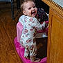 baby, child, walker, floral_onesie, smiling, happy, indoors, wooden_floor, furniture, cabinet, chair, person, standing, toy, cute, playtime, home, flooring, footwearless, infant