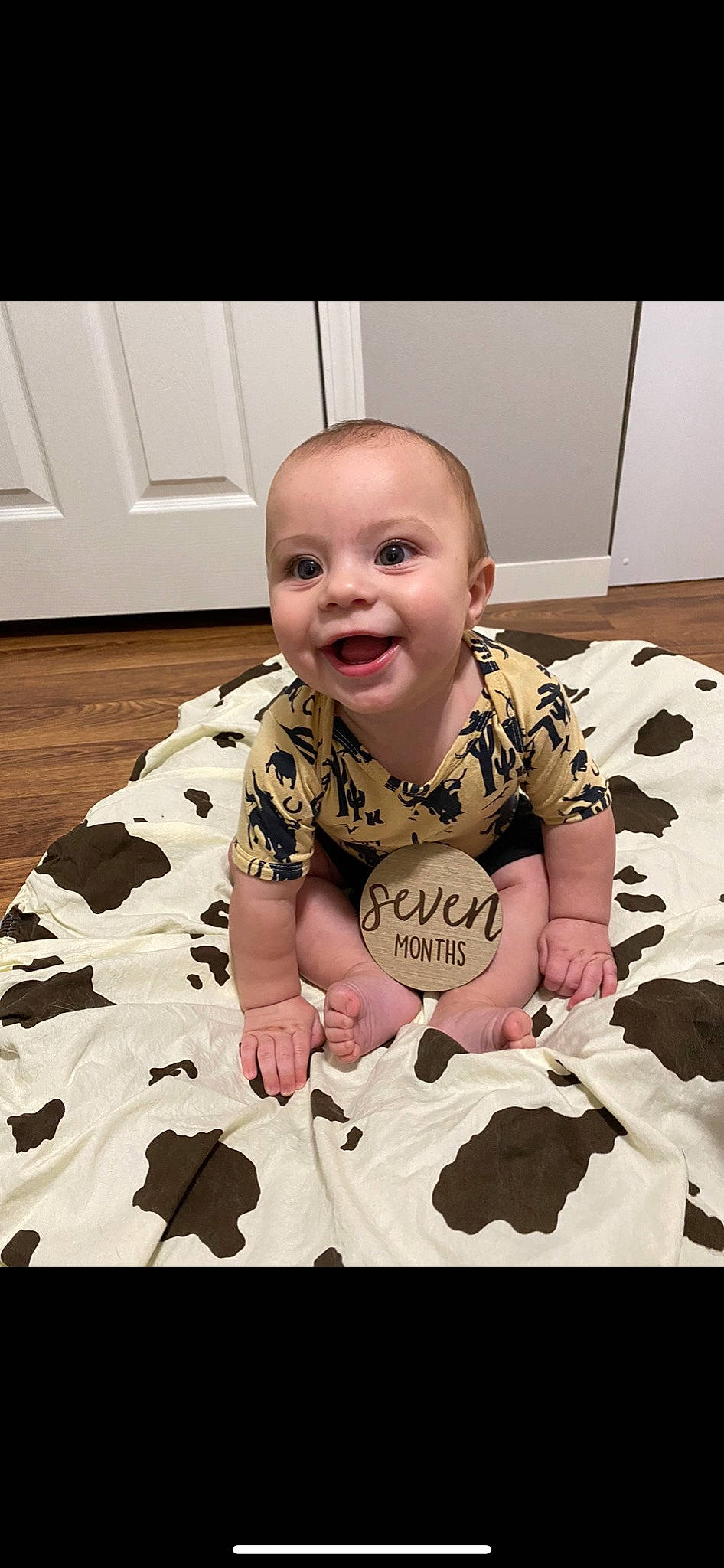 Stratton is registered to the contest to win money with this photo: arm, baby, baby_toddler_clothing, cheek, comfort, eye, face, facial_expression, flooring, hairstyle, hand, happy, head, mammal, mouth, nose, person, skin, sleeve, smile