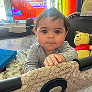 Michael is registered to the contest to win money with this photo: baby, child, playpen, plush_toy, winnie_the_pooh, indoor, curtain, television, window, hand, face, person, furniture, toy, clothing, smile, hair, eyes, light, home