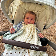 Soan a rejoint le concours — aidez-le/la à gagner de superbes lots ! baby, stroller, blanket, outdoor, child, face, infant, clothing, canopy, fabric, seat, nature, wood, pine_needles, hands, relaxed, cute, comfort, portrait, leisure