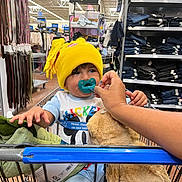 Matheo joined the competition — help win amazing prizes! toddler, child, shopping_cart, yellow_hat, pacifier, plush_toy, teddy_bear, hand, clothing, store_aisle, belts, shelves, jeans, retail, shopping, baby, cute, indoor, person, casual