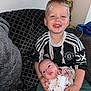 Cameron is registered to the contest to win money with this photo: baby, boy, casual, child, clothing, couch, cute, face, family, happy, holding, home, indoor, infant, manchester_united, pattern, person, sitting, smile, toy