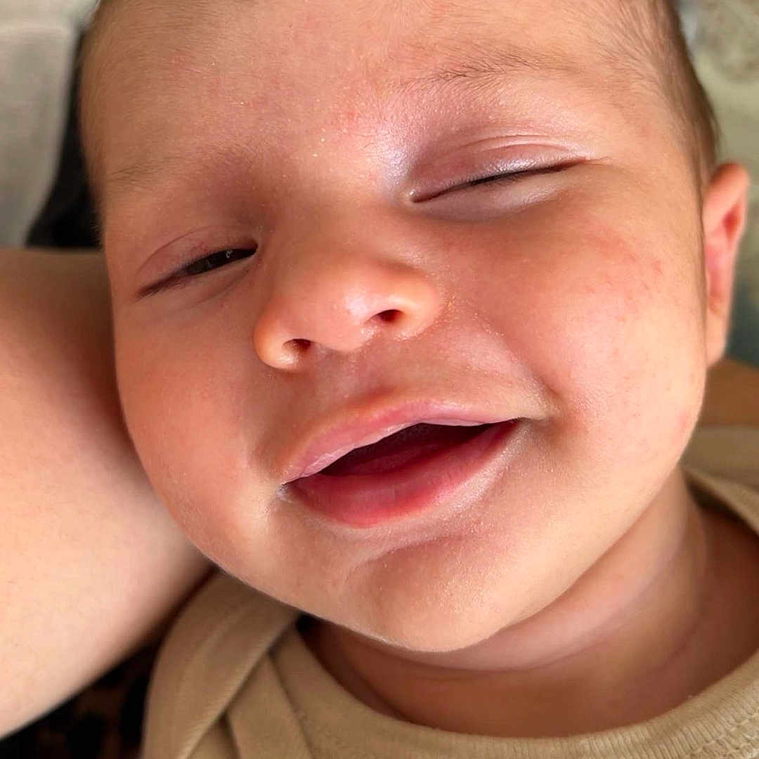 Thémys participe au concours pour gagner de l'argent avec cette photo : baby, baby_clothes, beige, child, close_up, clothing, cute, expression, face, head, human, indoors, infant, person, portrait, skin, sleepy, smile, soft_light, young