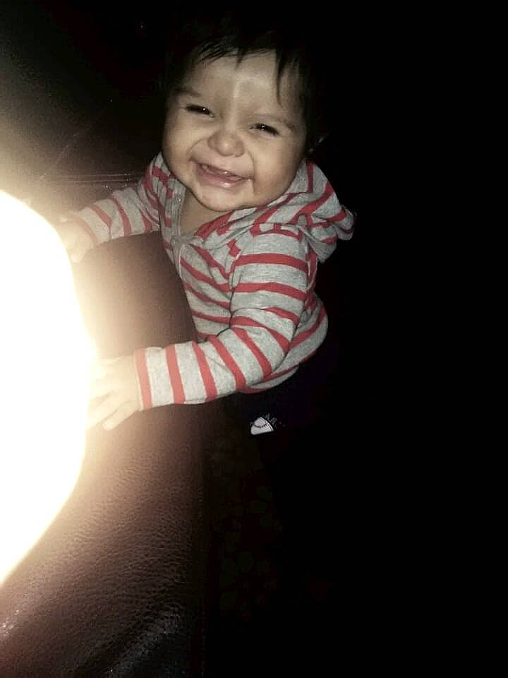 Josue is registered to the contest to win money with this photo: arm, black, cheek, child, emotion, eye, face, facial_expression, hand, head, human, human_body, joy, mouth, nose, person, sitting, skin, smile, standing