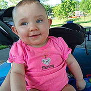 Adalynn is registered to the contest to win money with this photo: baby, child, pink_clothing, onesie, smiling, outdoor, pavilion, greenery, trees, sunny, park, infant, cute, happy, face, person, sitting, daylight, nature, casual